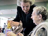 Koningin Beatrix schenkt een kopje koffie in voor een bewoonster van een verzorgingstehuis (Foto: ANP)